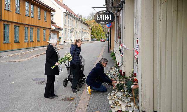 Passanten legen Blumen an einem der Tatorte im norwegischen Kongsberg nieder.