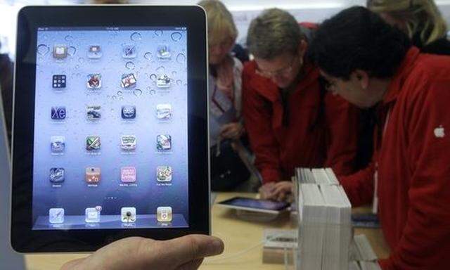 FILE - In this Nov. 26, 2010 file photo, a store employee holds up an iPad at an Apple Store in San F