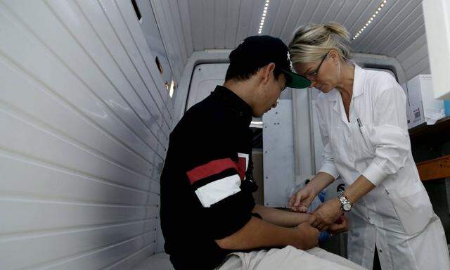 July 31 2015 Athens Greece A doctor examines an Afgani migrant inside a van in Athens on 31th