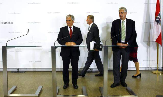 Austrian Vice Chancellor and Economics Minister Mitterlehner walks to join Chancellor Faymann and Finance Minister Schelling as they address a news conference after a government conclave in Schladming