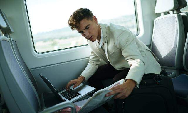 Young man using a laptop on a train model released Symbolfoto PUBLICATIONxINxGERxSUIxAUTxHUNxONLY KI