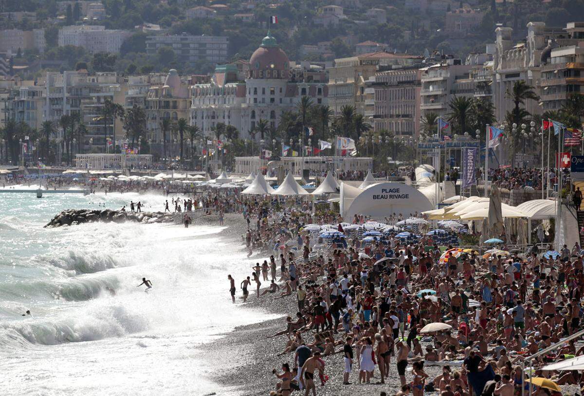Zu viele Badegäste sind an der Promenade Des Anglais in Cannes derzeit das geringste Problem - eher noch ihre Kleidung. Cannes hat das Tragen des Burkini am Strand unter Verweis auf die jüngsten islamistischen Terroranschläge verboten. "Es geht nicht darum, das Tragen religiöser Symbole am Strand zu verbieten, sondern ostentative Kleidung, die auf eine Zugehörigkeit zu terroristischen Bewegungen hinweist, die gegen uns Krieg führen", begründete der Generaldirektor der städtischen Dienste, Thierry Migoule. Bei Nichtbefolgung drohen 38 Euro Strafe.