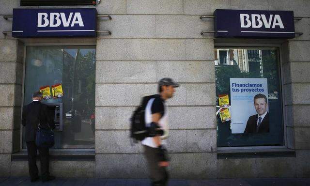 A man uses an ATM machine at a BBVA bank branch in Madrid