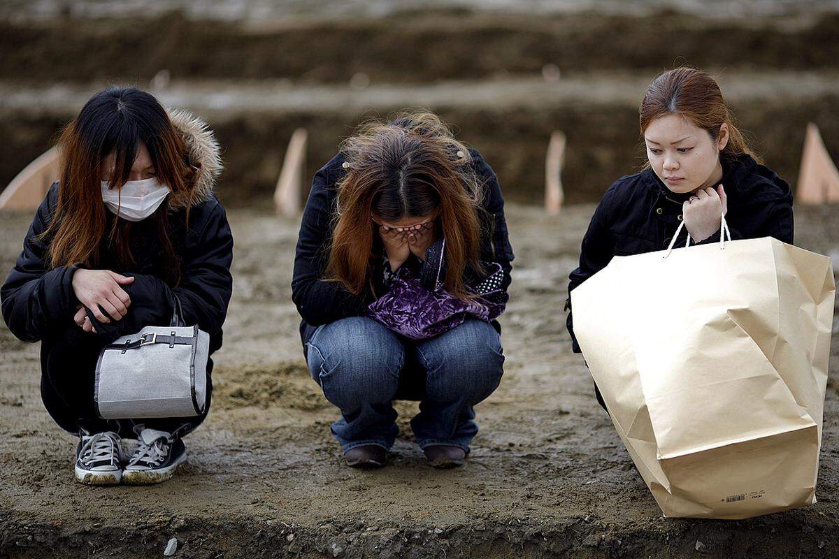 In Higashi-Matsushima wurde spontan ein Not-Friedhof errichtet. Drei Frauen trauern um Opfer der Katastrophe. (31. März)