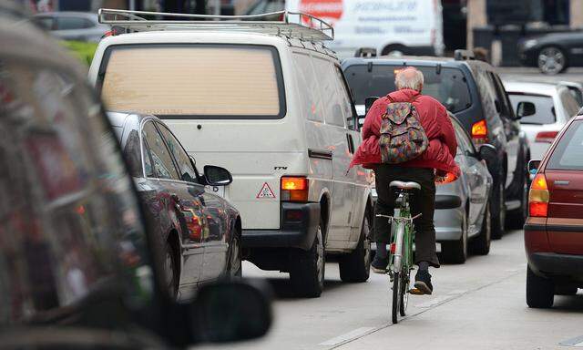 Ein Radfahrer im dichten Verkehr Wiens.