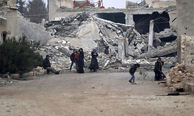 Zivilisten in einem zerbombten Ort.