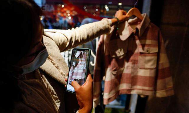 Eine Frau fotografiert ein Kleidungsstück bei AliExpress, dem Marketplace von Chinas Alibaba-Konzern.  