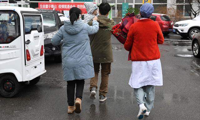 Familie Liu (links mit Kind) war an den neuen Coronaviren erkrankt. Nach mehreren Tagen im Pekinger Youan-Spital wurden die Lius am Freitag entlassen.