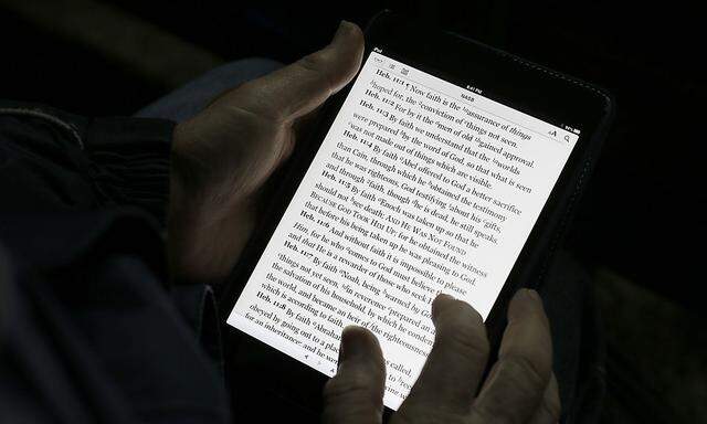 A man reads the bible from an iPad mini at the ´Christ is the Answer International Ministries´ group´s camp near Florence