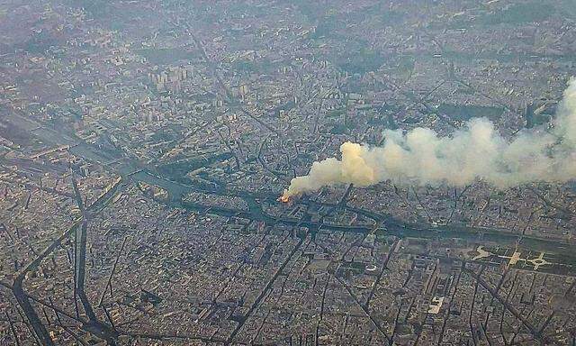 Ein Bild der Ile de la Cité und der brennenden Kathedrale Notre-Dame, das ein Flugzeug-Passagier im Vorbeiflug geschossen hat.