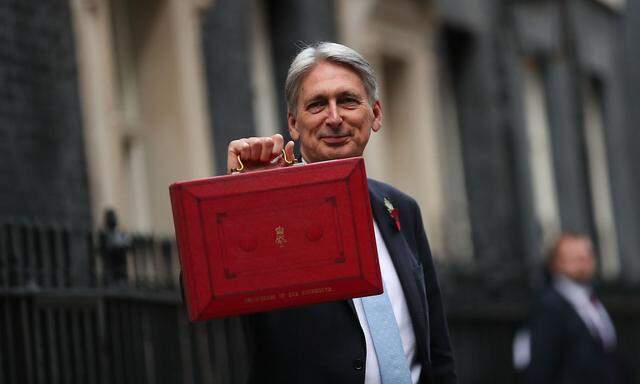 Auf Konfrontationskurs mit dem Verbündeten USA: Finanzminister Hammond (im Bild mit der "Budget Box", die von Mitgliedern der britischen Regierung für den Transport von offiziellen Dokumenten verwendet wird)