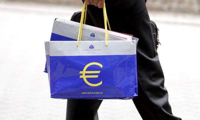 A man carrying a bag with the euro symbol on it arrives for a meeting of eurogroup finance ministers 