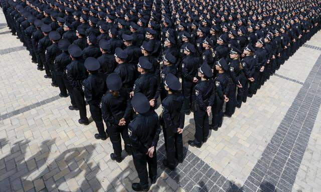 Police officers attend an oath-taking ceremony, which started up the work of a new police patrol service, in Kiev