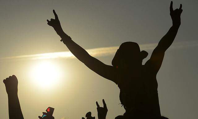 A heavy metal fan gives a heavy metal hand sign during a performance of British band Deep Purple at the 24th Wacken Open Air Festival in Wacken