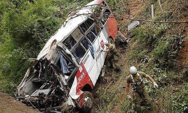 Policemen inspect a passenger bus after an accident along Route CH-150, known as Cuesta Caracol, in Tome city near Concepcion