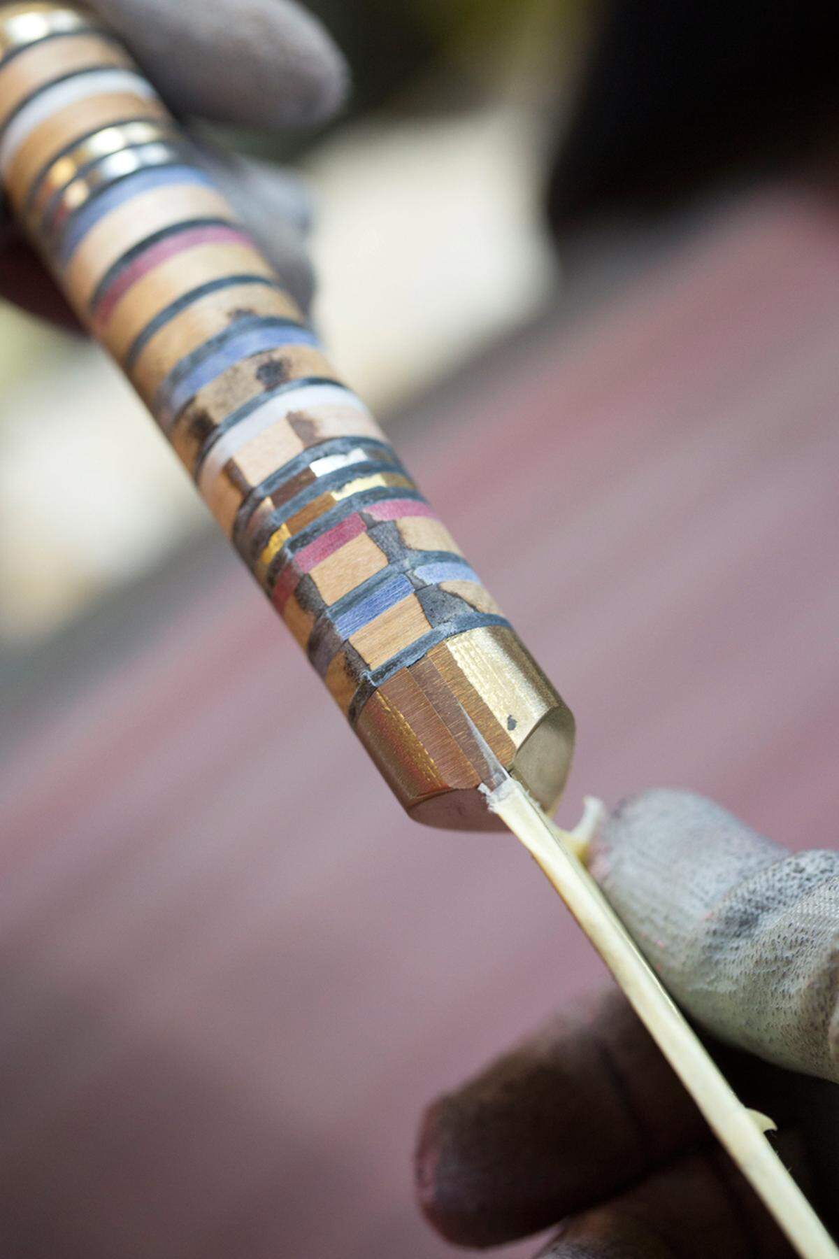 Für den Griff werden Scheiben aus Stahl, Leder und Holz aneinander-gereiht.
