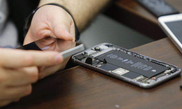 A worker checks an iPhone in a repair store in New York