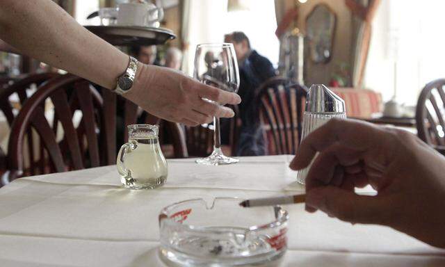 A customer smokes a cigarette in a cafe in Vienna