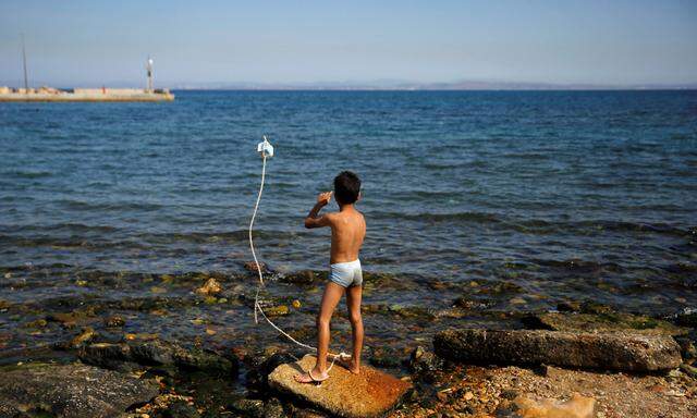 File photo of a Syrian boy playing next to the sea at the Souda municipality-run camp for refugees and migrants, on the island of Chios