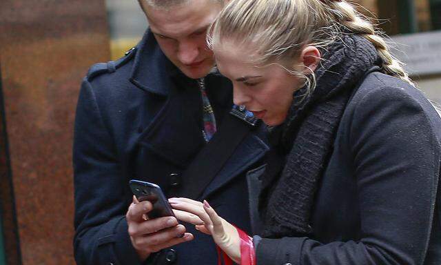 People use their smartphones in New York City