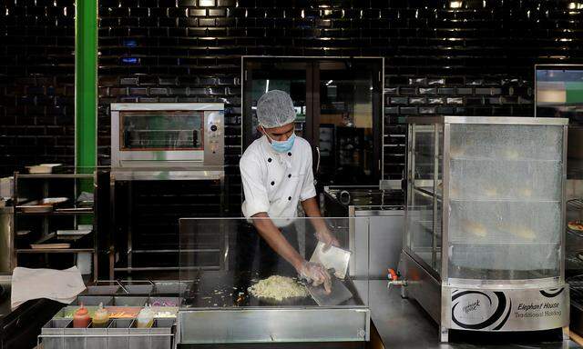 A chef wearing a protective mask cooks at the kitchen at a Keels super market for customers, amid concerns about the spread of the coronavirus disease, in Colombo