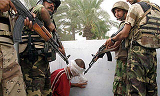 Irakische Soldaten bewachen einen an einem Kontrollposten verhaften Mann, der verdächtigt wird, mit al-Qaida zusammenzuarbeiten.