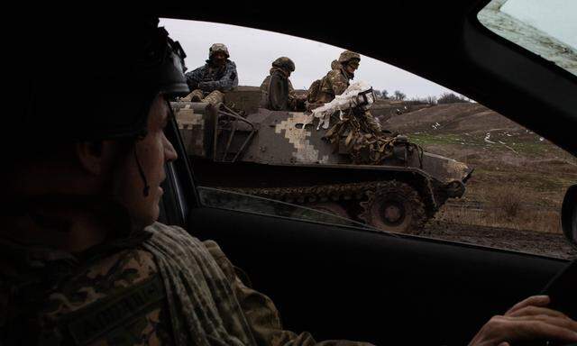 Ukrainische Soldaten fahren mit einem gepanzerten Fahrzeug in der Nähe der Frontstadt Chasiv Yar. Die Stadt Chasiv Jar steht weiterhin unter schwerem Beschuss russischer Stellungen.