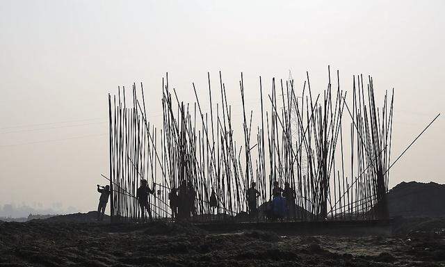 Labourers work at the construction site of a bridge being built over the river Yamuna for metro rail in New Delhi