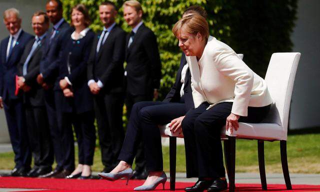 Die deutsche Kanzlerin, Angela Merkel, saß diesmal beim Abspielen der Nationalhymne.