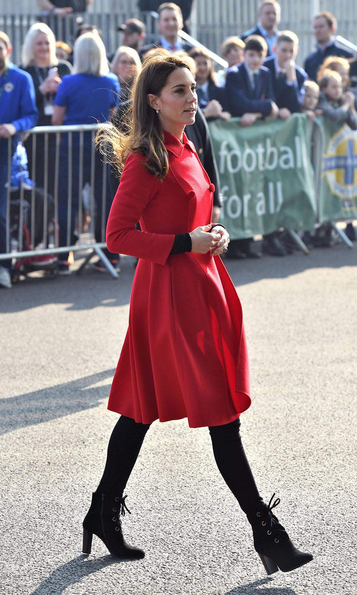 Die Royals sind zu Besuch in Belfast, Nordirland – und Baronin Carrickfergus, so lautet der irische Titel von Herzogin Catherine (Prinz William darf sich in Irland Baron von Carrickfergus nennen), sorgt in einem roten Mantel von Carolina Herrera dafür, dass sie auch ja niemand übersieht. Übersehen wollen wir wieder Mal die Kombination aus schwarzem Beinkleid und schwarzem Schuhwerk, auch wenn ihre Booties von LK Bennett etwas Pep in das Outfit bringen. Etwas Bling-Bling verschaffen ihr die Lauren-Ohrringe von Kiki McDonough.