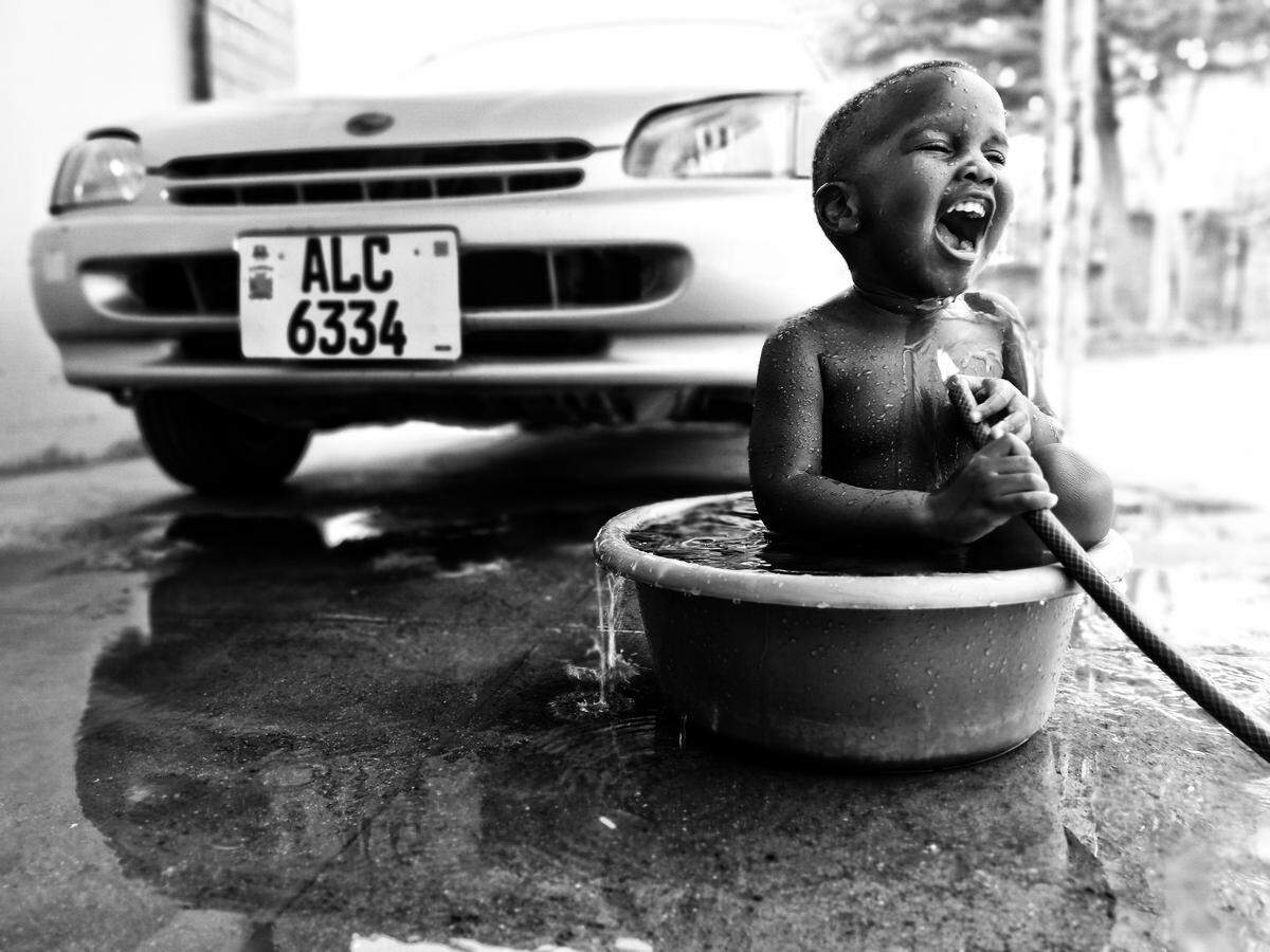 Dieses Foto wurde in Sambia im südlichen Afrika aufgenommen. "Der Oktober ist ein Sommermonat auf dieser Seite der Welt, an diesem Tag war es unglaublich heiß. Mit dem Wasser müssen wir hier sehr sparsam umgehen. Ich habe gerade mein Auto gewaschen und mein Sohn hat beschlossen, ein Bad zu nehmen. Ich habe es ihm erlaubt, denn in seinem Gesicht standen pure Freude und Glück", so User @bonkoti.