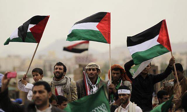 People wave Palestinian flags during a rally to show solidarity to Gaza, in Sanaa