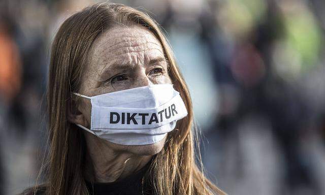 Frau mit "Diktatur"-Maske