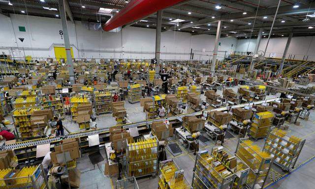 Employees work at the Amazon distribution center in Saran, near Orleans