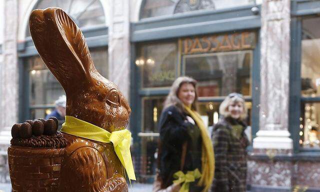 Two women walk past a chocolate Easter bunny at Belgian chocolate maker Neuhaus in Brussels