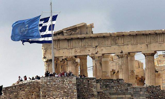 Greek and United Nations flags flutter atop the Athens Acropolis on United Nations Day in Athens
