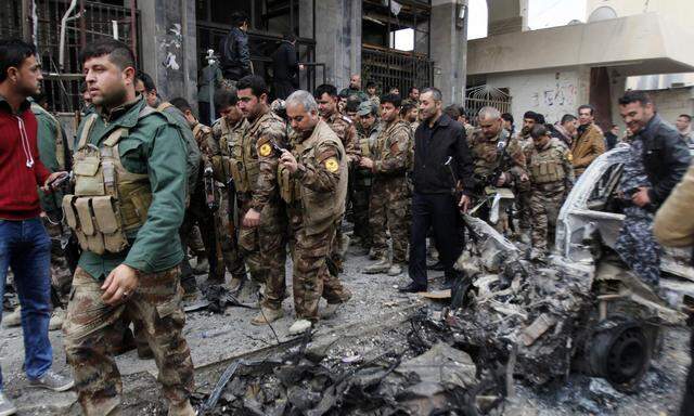 Members of the Kurdish security forces inspect the site of bomb attack in Kirkuk