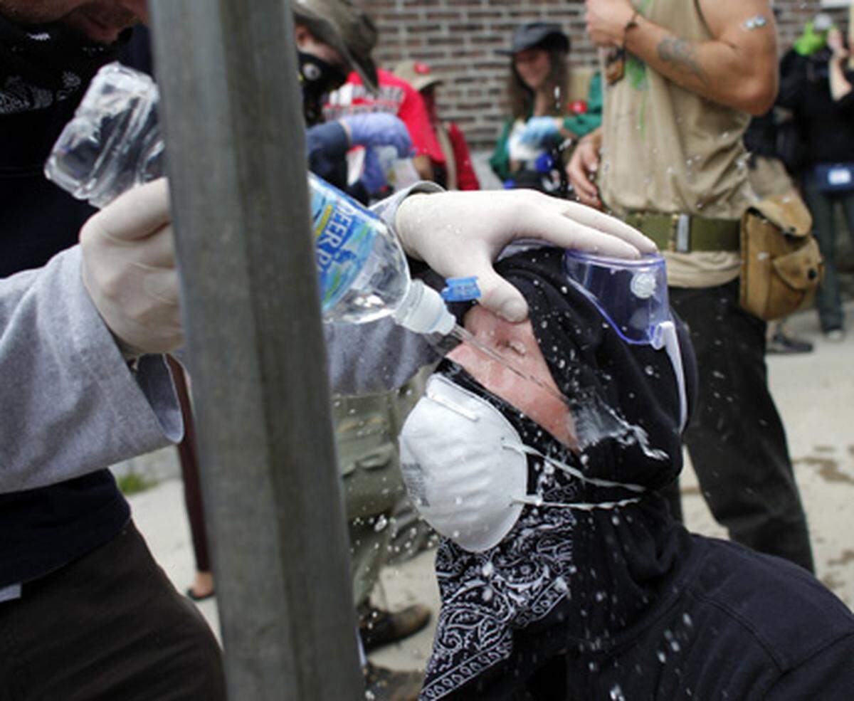 Demonstranten sprühten sich Wasser ins Gesicht, um das Reizgas auszuspülen.
