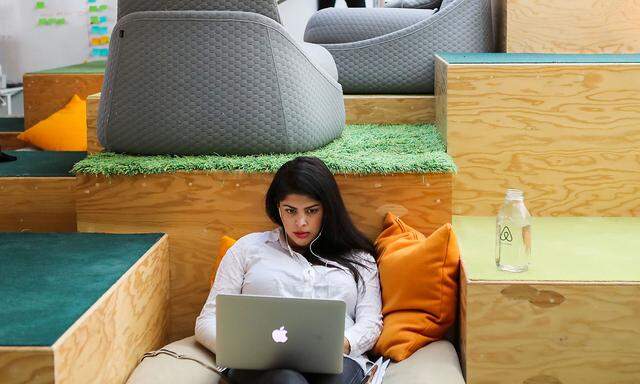 A woman works at her Apple computer at the Airbnb office headquarters in the SOMA district of San Francisco