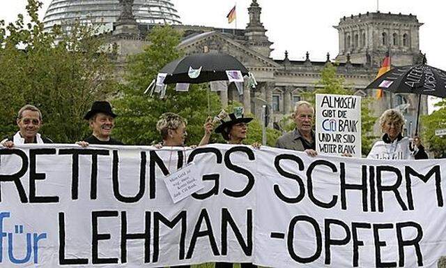 Protestors hold banner during demonstration for people affected by Lehman bankruptcy  in Berlin