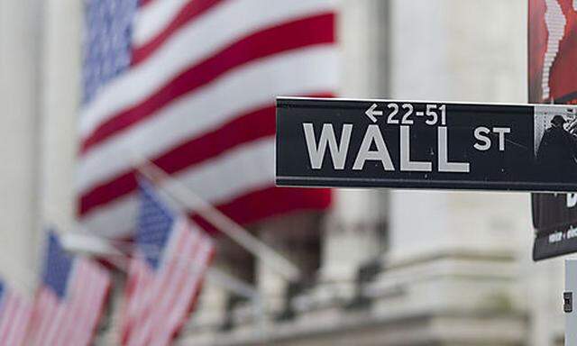 In this Aug. 8. 2011 photo, a Wall Street sign hangs near the New York Stock Exchange, in New York. S