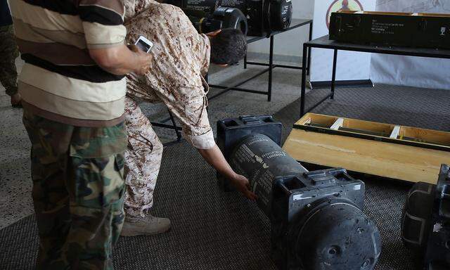 Libysche Kämpfer präsentieren aufgefundene Panzerabwehrraketen.