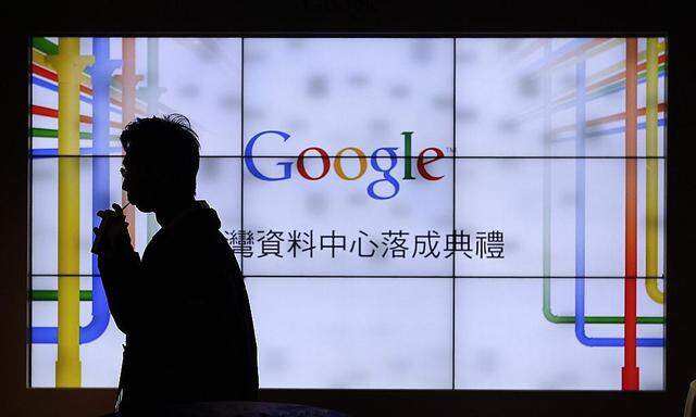 A man walks past a TV wall during a media tour at the Google data centre in central Taiwan