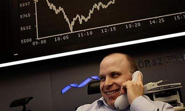 A share trader smiles as he talks on the phone during mid-day trading at Frankfurts stock exchanges stock exchange