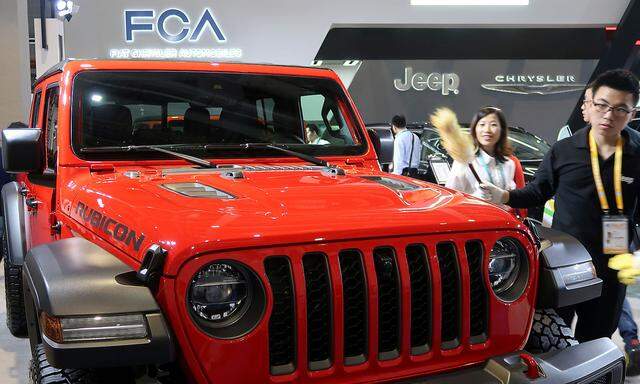 FILE PHOTO: Staff member cleans a Jeep Gladiator pickup truck displayed at the Fiat Chrysler Automobiles (FCA) booth during the second China International Import Expo (CIIE) in Shanghai