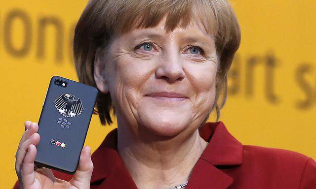 German Chancellor Merkel holds a BlackBerry Z10 smartphone featuring high security Secusite software at the booth of Secusmart during her opening tour at the CeBit computer fair in Hanover