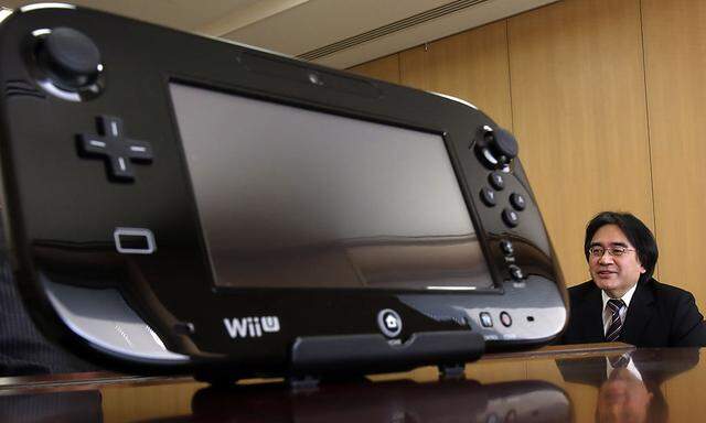 Nintendo Co´s President Satoru Iwata speaks next to company´s Wii U game controller during an interview with Reuters at the company headquarters in Kyoto, western Japan