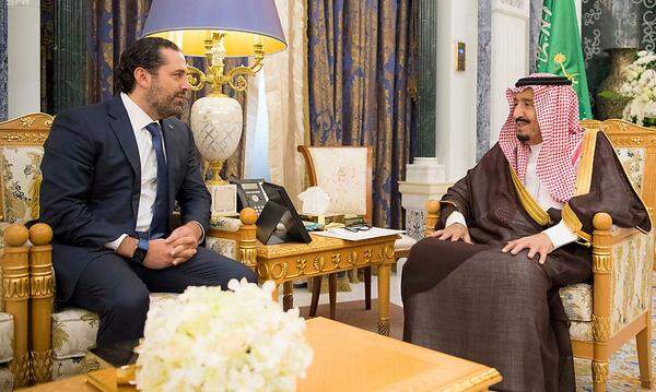 Das libanesische Parlament ist tief gespalten zwischen dem von den USA und dem sunnitischen Saudiarabien unterstützten Lager um den zurückgetretenen Ministerpräsidenten Saad al-Hariri (im Bild mit dem saudischen König) und einem von der schiitischen Hisbollah angeführten Block, der vom Iran und von Syrien unterstützt wird. Staatschef Michel Aoun ist maronistischer Christ. Das Waffenarsenal der Hisbollah ist mittlerweile umfangreicher als das der libanesischen Armee. Die Miliz beansprucht für sich, der einzige Schutz des Libanon gegen mögliche Angriffe durch das benachbarte Israel zu sein. Die politischen Gräben haben sich durch den Bürgerkrieg im Nachbarland Syrien, in dem die Hisbollah auf der Seite von Machthaber Bashar al-Assad kämpft, weiter vertieft.