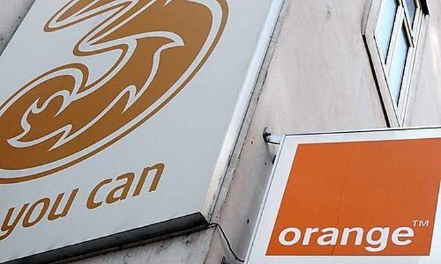 The logos of Orange and 3 are pictured outside a telecommunications store in Vienna