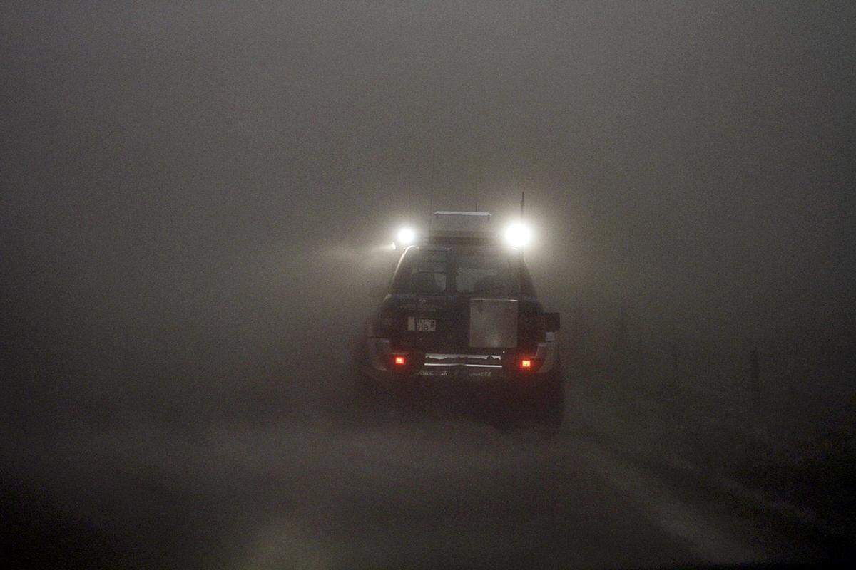 Ein Auto bahnt sich bei Kirkjubaejarklaustur seinen Weg durch den Nebel.